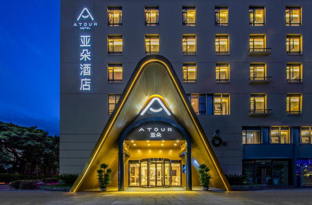 a hotel with a large building with a sign on it at Atour Hotel Shenzhen Nanshan Shekou in Shenzhen