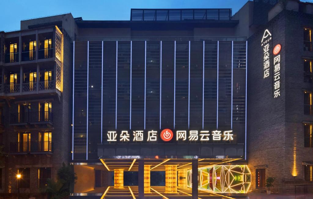 ein Gebäude mit einem Schild auf der Vorderseite in der Unterkunft Atour Hotel Chongqing Tiandi NetEase Cloud Music in Chongqing