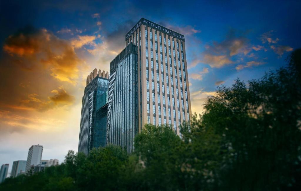 a tall building in a city under a cloudy sky at Atour Hotel Xining East Kunlun Road in Xining