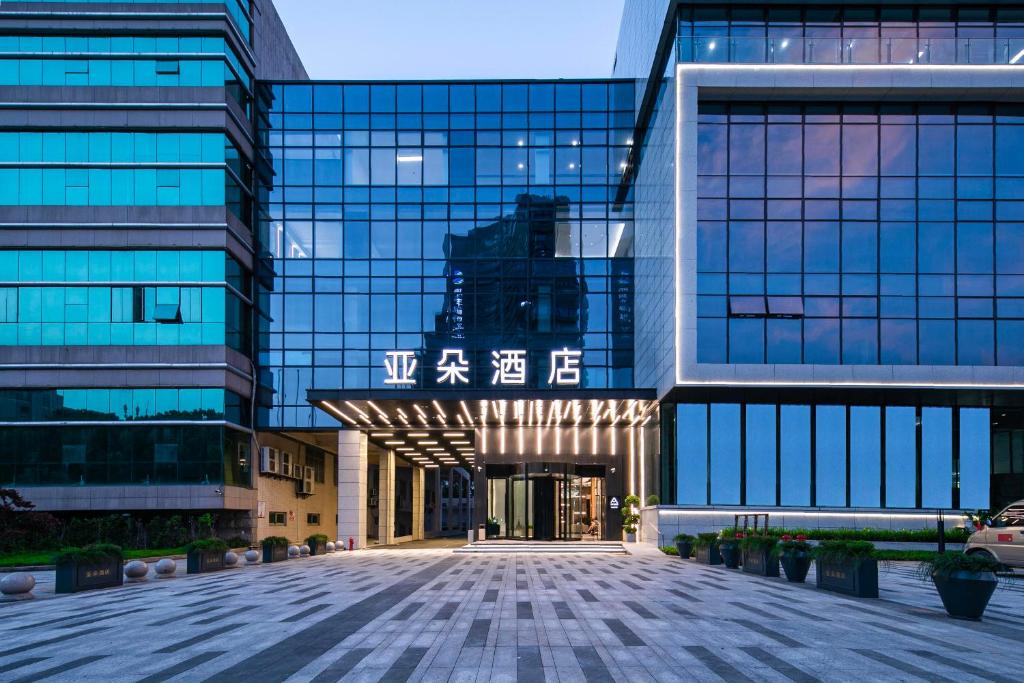 un edificio de oficinas con una fachada de cristal en Atour Hotel Shaoxing Heqiao, en Shaoxing