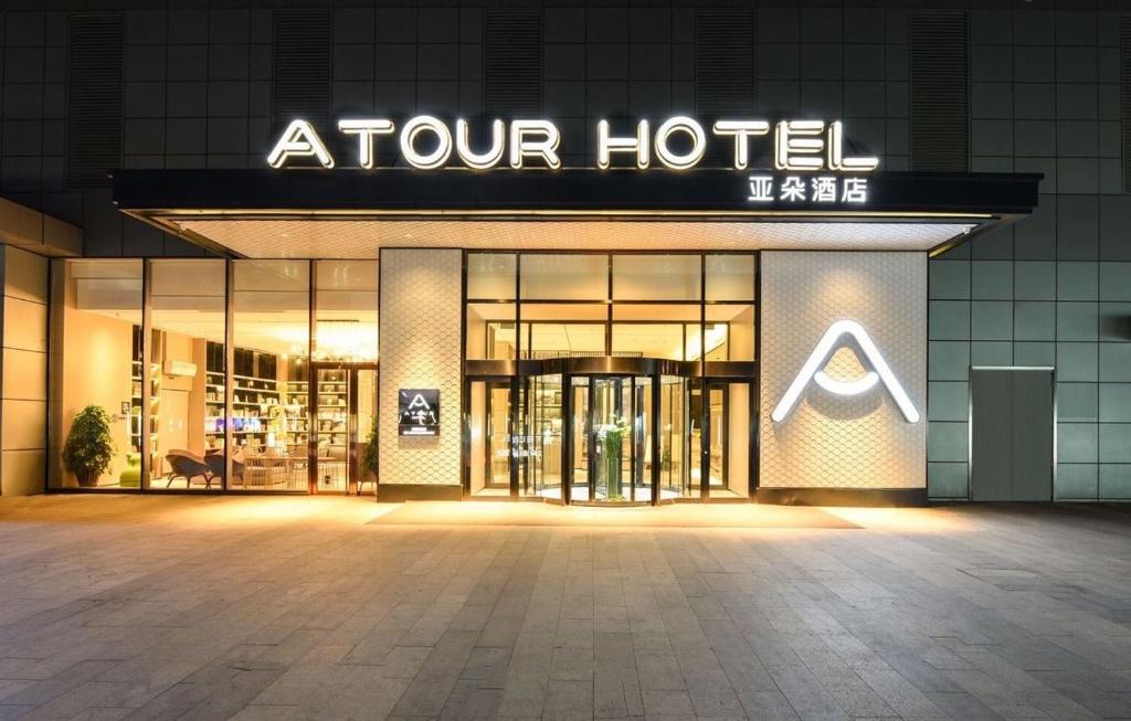 Atour Hotel Shenyang Youth Street Golden Gallery في شنيانغ: متجر أمام الفندق في الليل