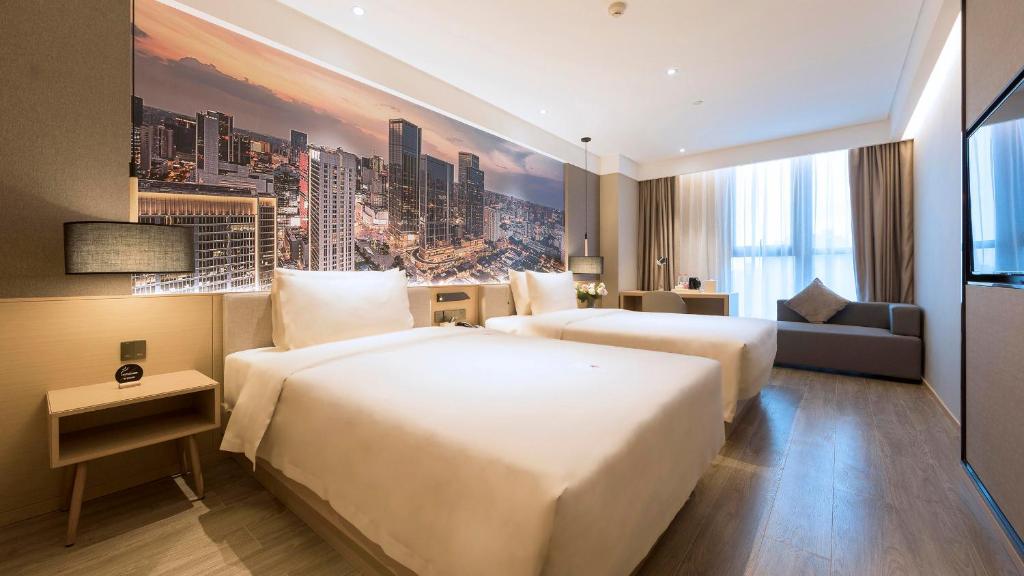 um quarto de hotel com duas camas e um sofá em Atour Hotel Chengdu Jiuyanqiao NetEase Selected em Chengdu