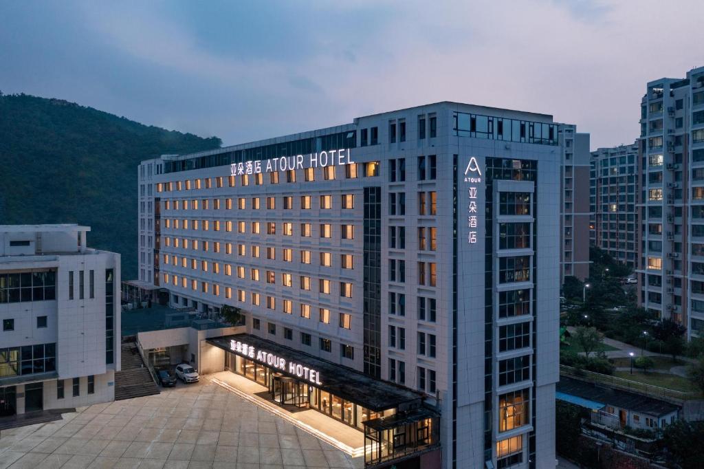 un edificio con un cartel en el costado en Atour Hotel Qingdao Laoshan Shilaoren Beach en Qingdao