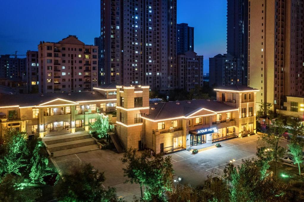 een groot gebouw in een stad 's nachts bij Atour Hotel Jinan Zhangqiu Century Avenue in Jinan