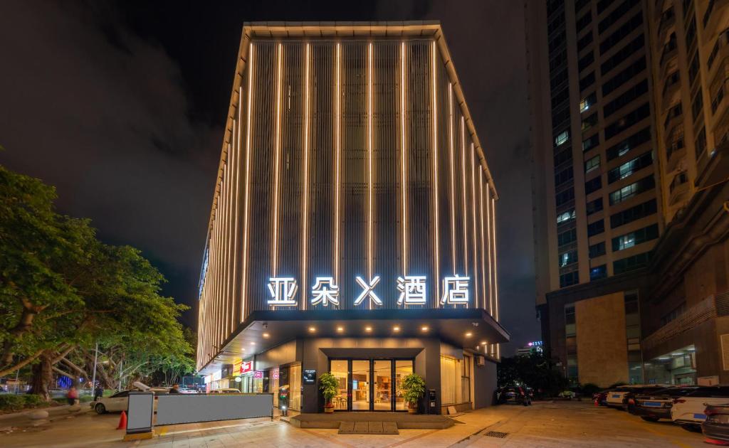 un edificio con una fachada iluminada por la noche en Atour X Hotel Zhuhai Gongbei Port High Speed Railway Station, en Zhuhai