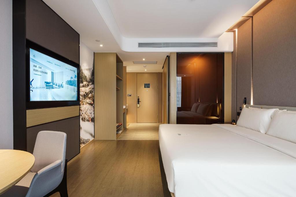 泰安泰安泰山景区盘古天地亚朵酒店的卧室里有一张白色的大床和一台平板电视