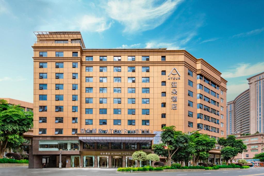 泉州市にあるAtour Hotel Quanzhou Hongchang Baozhou Roadの目の前に木々が植えられた茶色の大きな建物