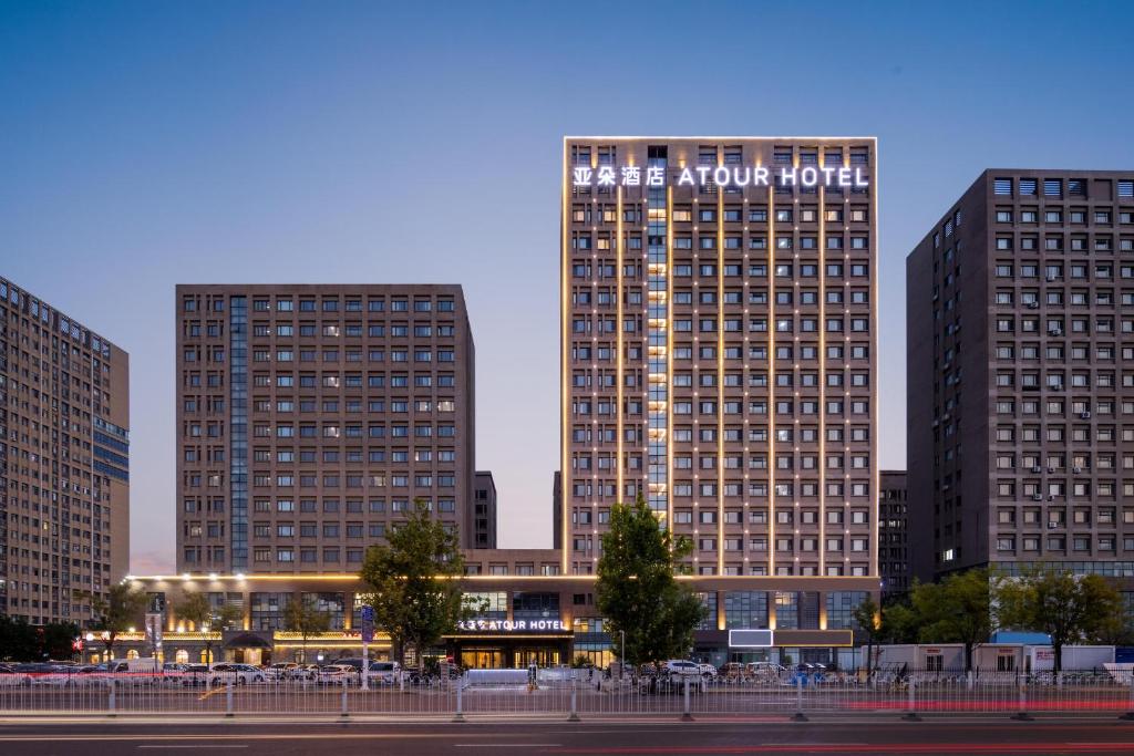 tres edificios altos en una ciudad por la noche en Atour Hotel Tianjin Zhongbei Haitai Industrial Park, en Tianjin