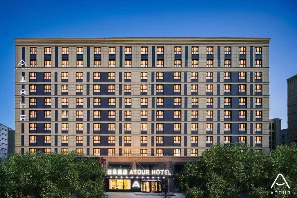 un gran edificio con luces encendidas en una ciudad en Atour Hotel Urumqi Airport Degang Wanda, en Ürümqi