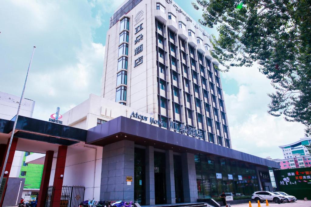 un edificio blanco alto en una calle de la ciudad en Atour Hotel Qinhuangdao Railway Station Yingbin Road en Qinhuangdao