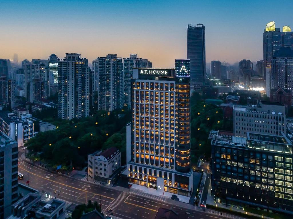 un edificio iluminado en una ciudad por la noche en A T HOUSE Shanghai Xujiahui, en Shanghái