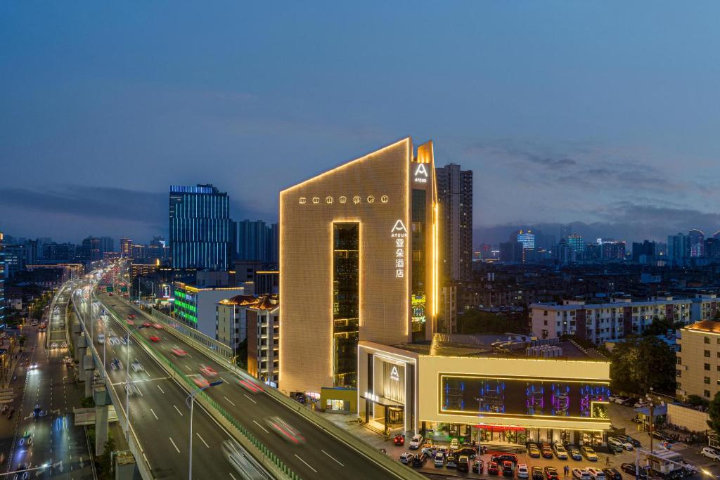 ein großes Gebäude mitten in einer Stadt mit Verkehr in der Unterkunft Atour Hotel Nanchang Bayi Square Provincial Television Station in Nanchang