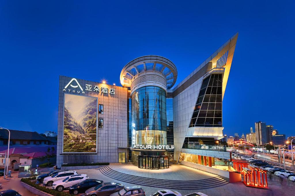 天津的住宿－天津之眼亚朵酒店，停车场内停放汽车的大型建筑