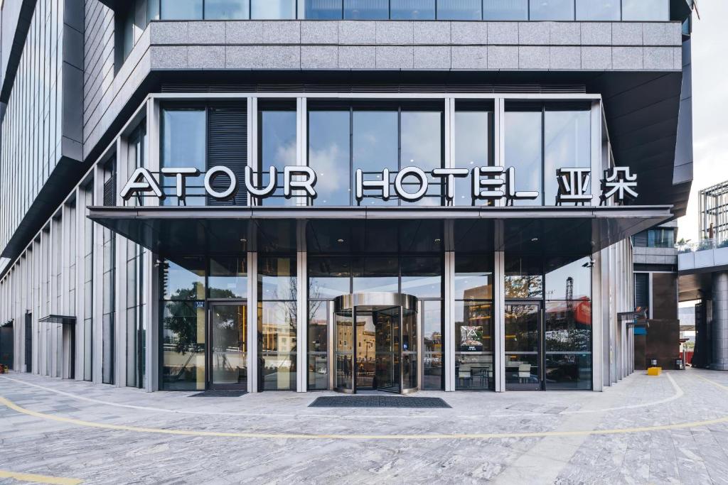 un hotel con un cartel en la parte delantera de un edificio en Atour Hotel Ningbo Laowaitan, en Ningbo