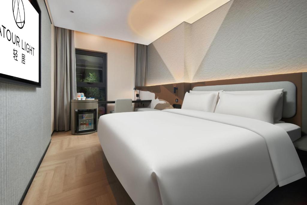 - un grand lit blanc dans une chambre d'hôtel dans l'établissement Atour Light Hotel Changsha IFC Huangxing Road Pedestrian Street, à Changsha