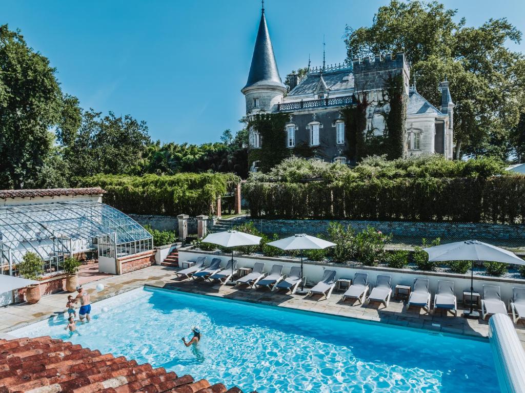 una piscina di fronte a una casa con un edificio di Château Belle Epoque - Chambres d'Hôtes & Gîtes a Linxe