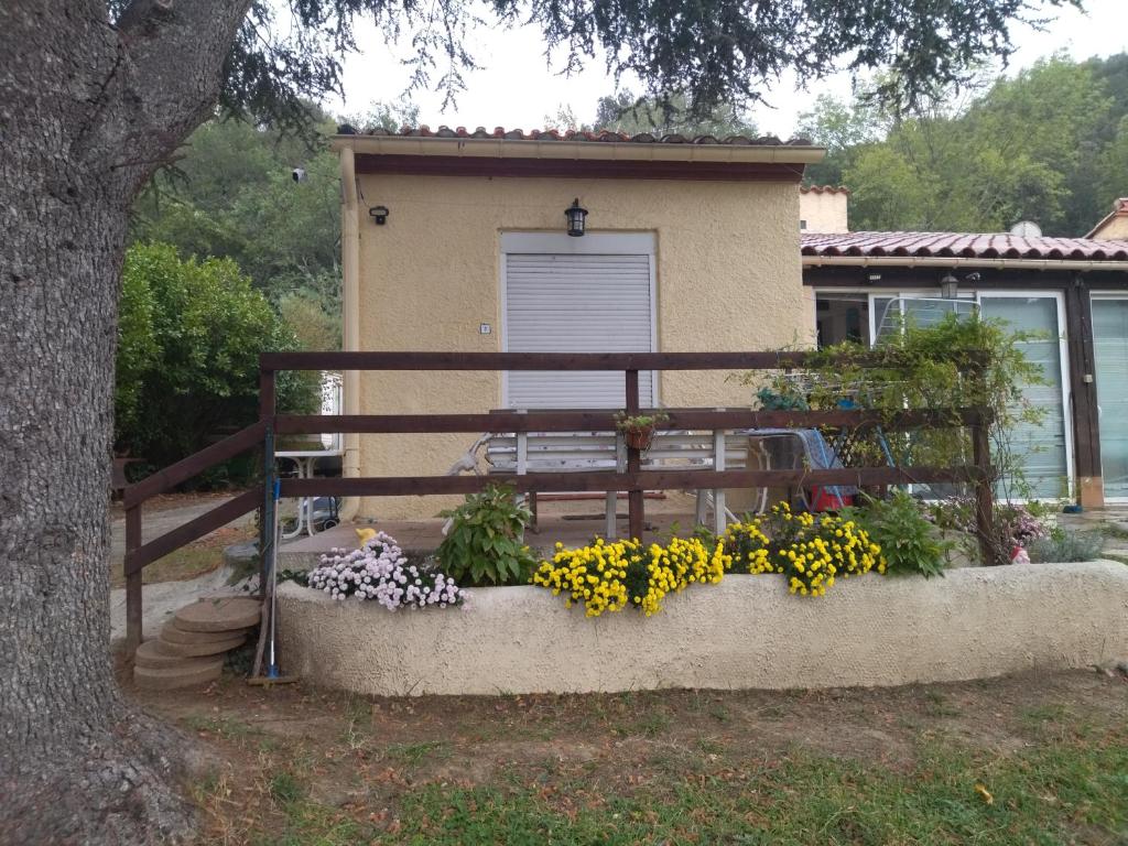 Une clôture avec un bouquet de fleurs devant une maison dans l'établissement F1 chambre et cuisine, à Reynès