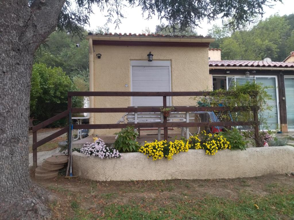 a fence with a bunch of flowers in front of a house at F1 chambre et cuisine in Reynès