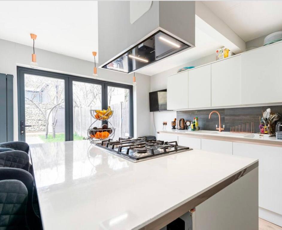 a kitchen with a white counter top and a stove at Cozy private room in London