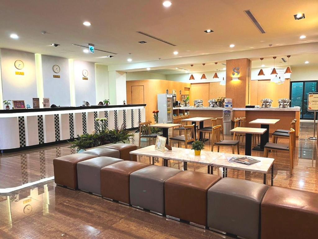 a restaurant with benches and tables and a bar at San Juan Easy Stay Inn Tainan in Tainan