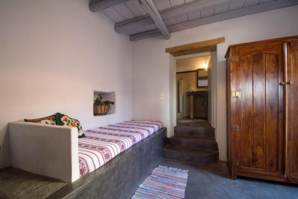 a bedroom with a bed and a wooden door at Abramis Rooms in Mitáta