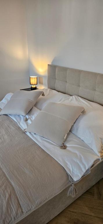 1 cama grande con sábanas y almohadas blancas en Cztery Kąty w Rynku, en Wałbrzych