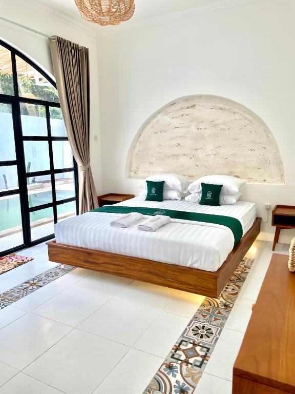1 dormitorio con 1 cama grande en una habitación con ventanas en Sampai Villa Santiva en Pedes