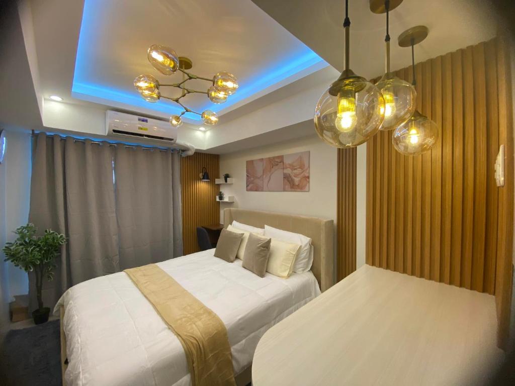 une chambre d'hôtel avec deux lits et une lumière bleue dans l'établissement BALI TOWER AZURE NORTH RESIDENCES, à Lagundi