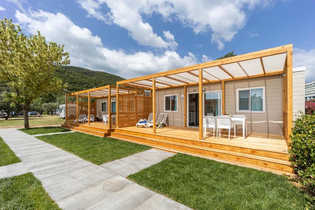 a modular home with a deck and grass at Camping Residence Oliva in Rabac