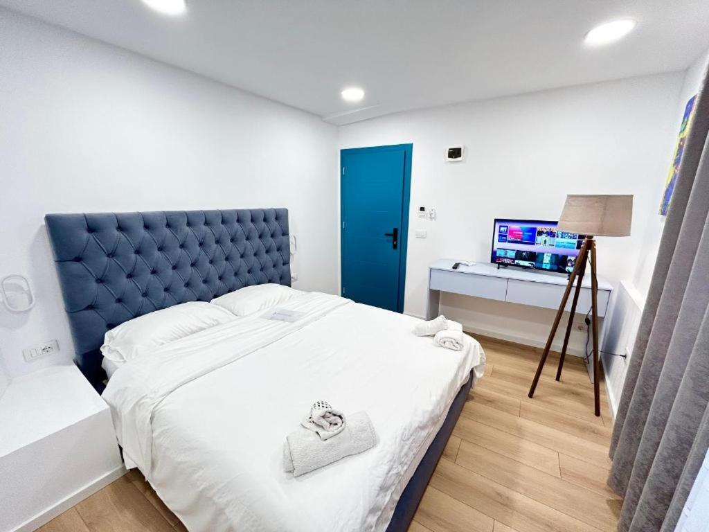 a bedroom with a large bed with a blue headboard at Tirana Square Hotel in Tirana