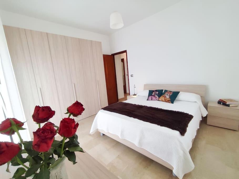 Schlafzimmer mit einem Bett mit roten Rosen in der Unterkunft White Sea - Luminoso Appartamento a 200mt dal mare in Spadafora