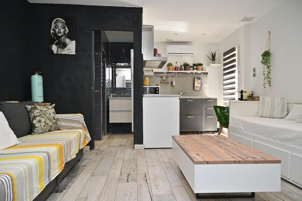 un soggiorno con divano e cucina di Studio Cosy " La Tarente Dorée " a Fréjus