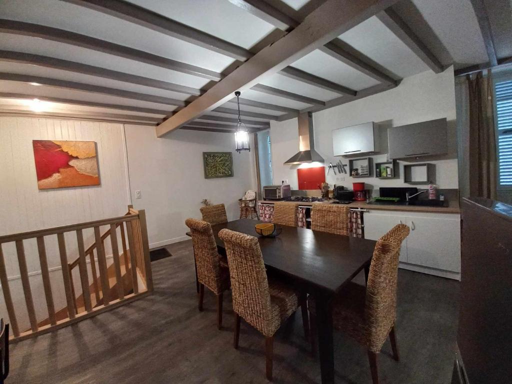 eine Küche und ein Esszimmer mit einem Tisch und Stühlen in der Unterkunft Apart sud vendee, zen et confort centre bourg in Saint-Hilaire-des-Loges