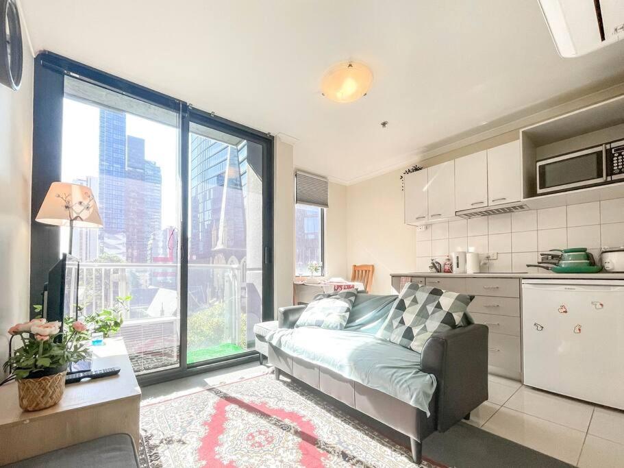 un soggiorno con divano e una cucina di Compact 2B1B Centre of CBD near QV Shopping Centre a Melbourne