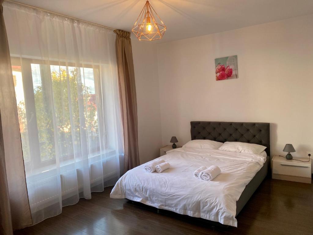 a bedroom with a bed with white sheets and a window at InnTime in Cluj-Napoca