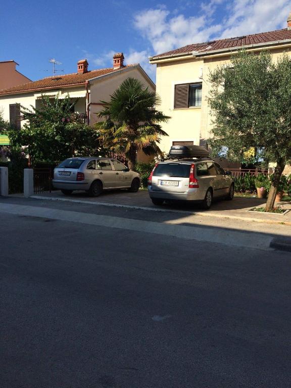 two cars parked on the side of a street at Apartment Bogdanovic in Fažana