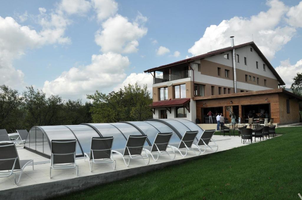 un grupo de sillas sentadas en un patio frente a un edificio en Pensiunea Muntele Verde en Slănic