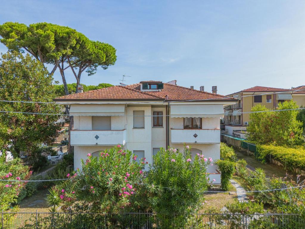 a white house with a red roof at Apartment Dei Fiori by Interhome in Lido di Camaiore