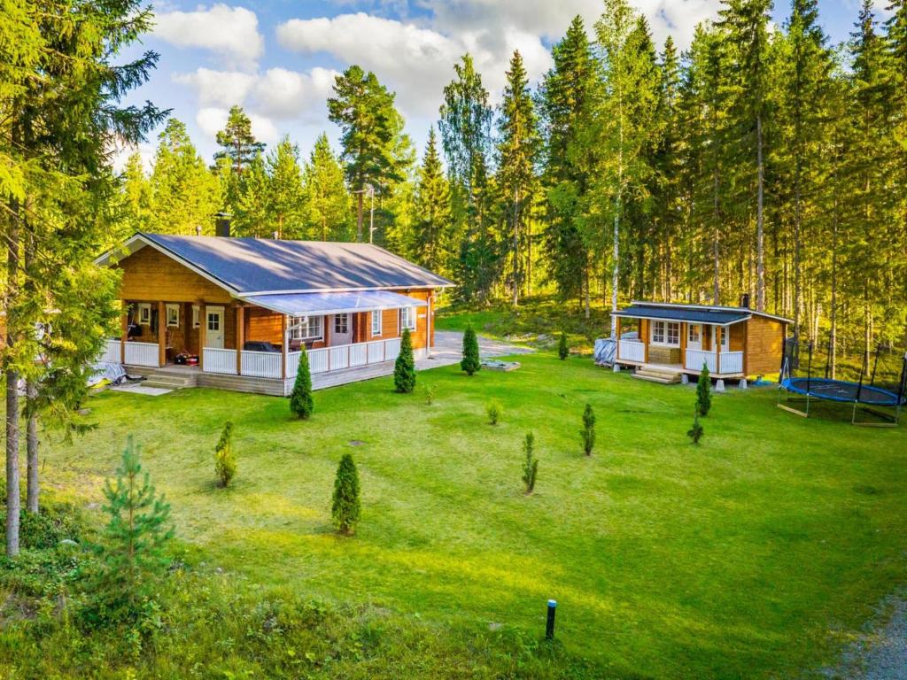 ein Haus inmitten eines Hofes mit Bäumen in der Unterkunft Holiday Home Aapeli iso by Interhome in Inhantehtaat