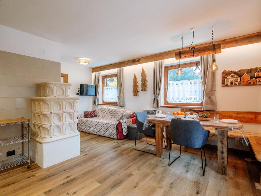 Una cocina y una sala de estar con mesa y sillas. en Apartment Storie di Montagna by Interhome, en Campestrin