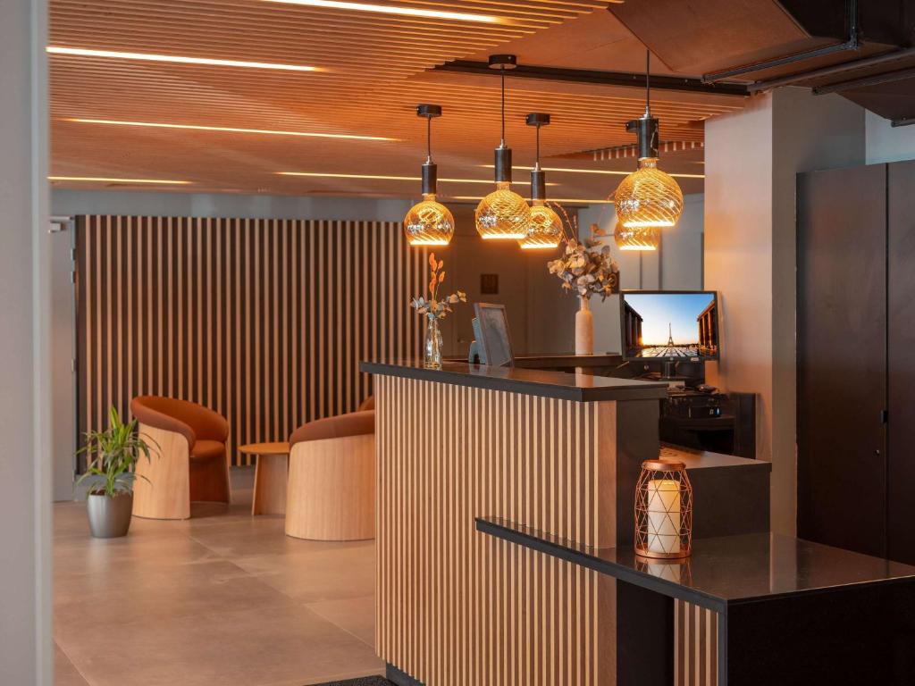 a lobby with a bar with chairs and pendant lights at ibis Styles Fontenay in Fontenay-sous-Bois