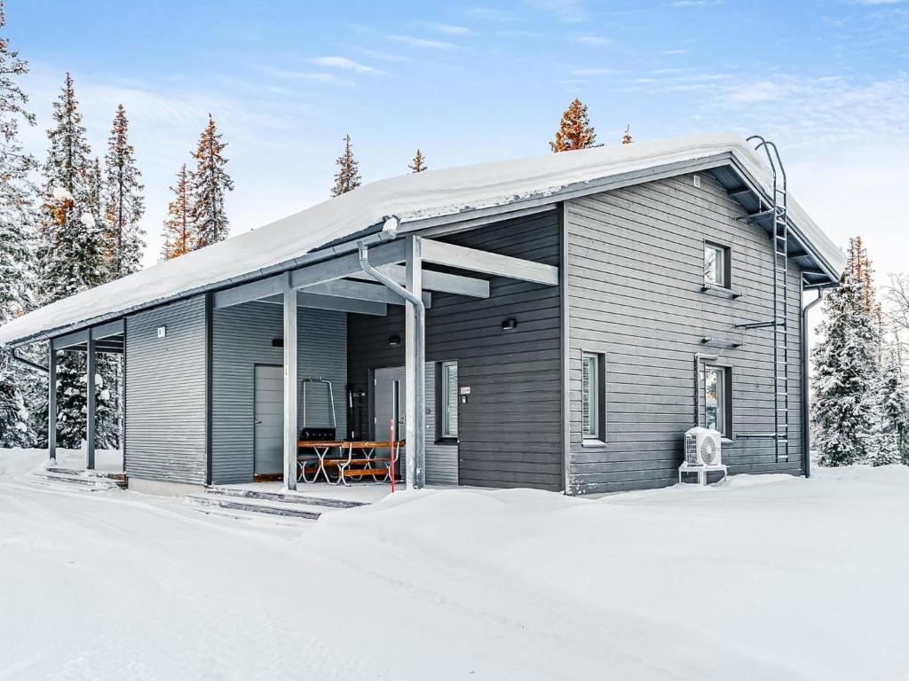 a house with a gambrel roof in the snow at Holiday Home Villa vuosseli b 1 by Interhome in Ruka
