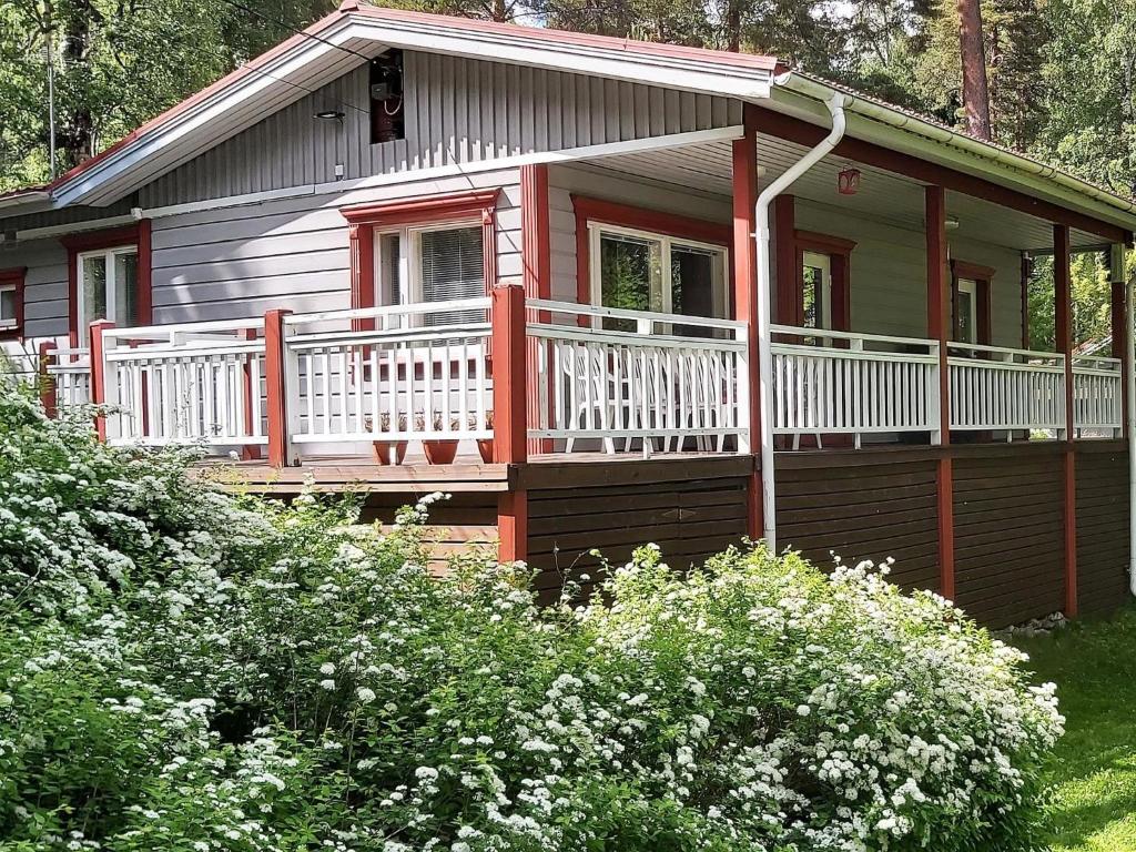 a small house with a porch and white railing at Holiday Home Lomaranta by Interhome in Paksalo