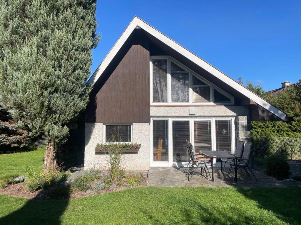 une maison avec une table et des chaises dans une cour dans l'établissement Holiday Home Zhorska by Interhome, à Planá nad Lužnicí