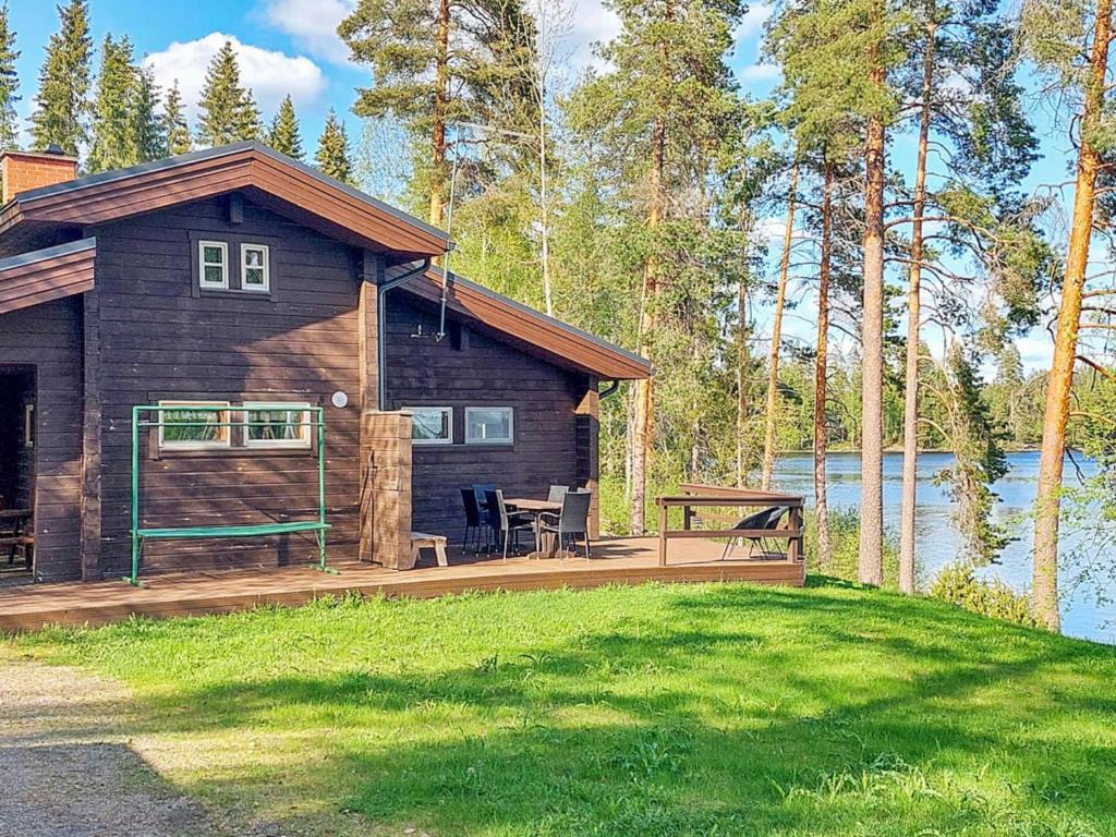PetäjävesiにあるHoliday Home Petäjälahti by Interhomeの湖畔のデッキ付きのログキャビン