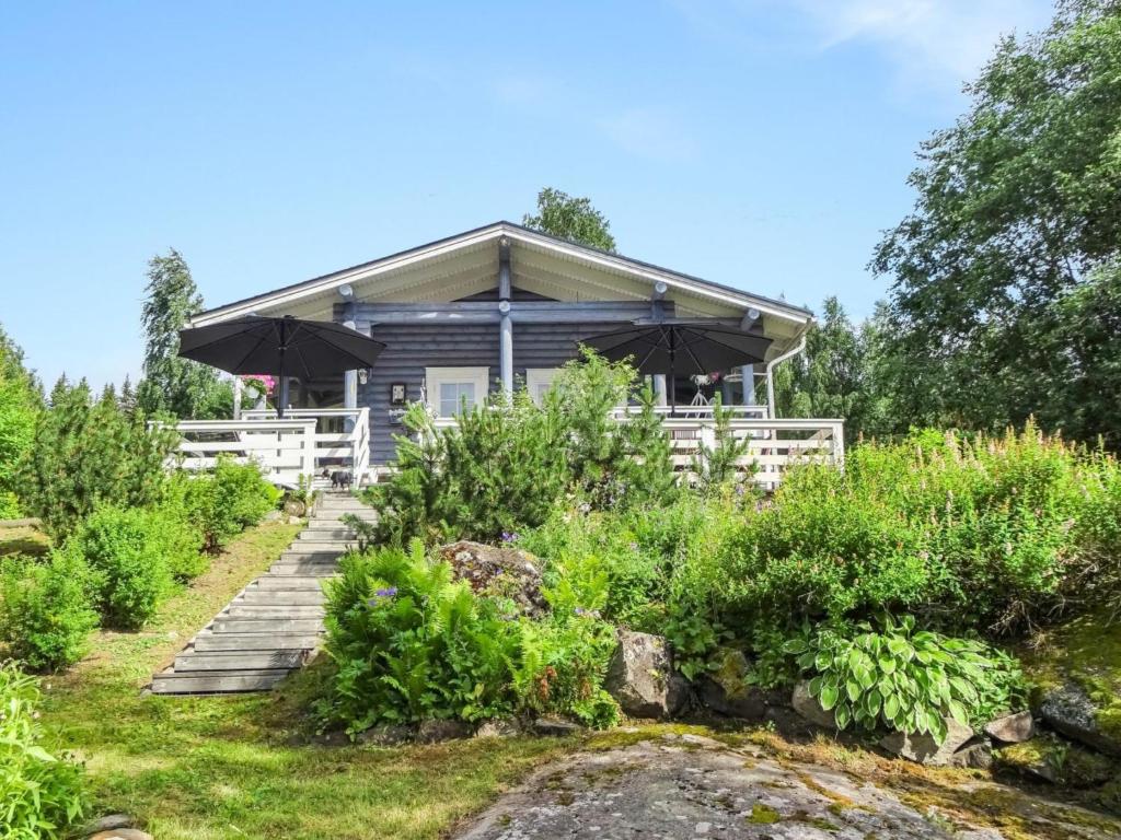 a house in the middle of a garden at Holiday Home Käpälysmökki by Interhome in Nurmes