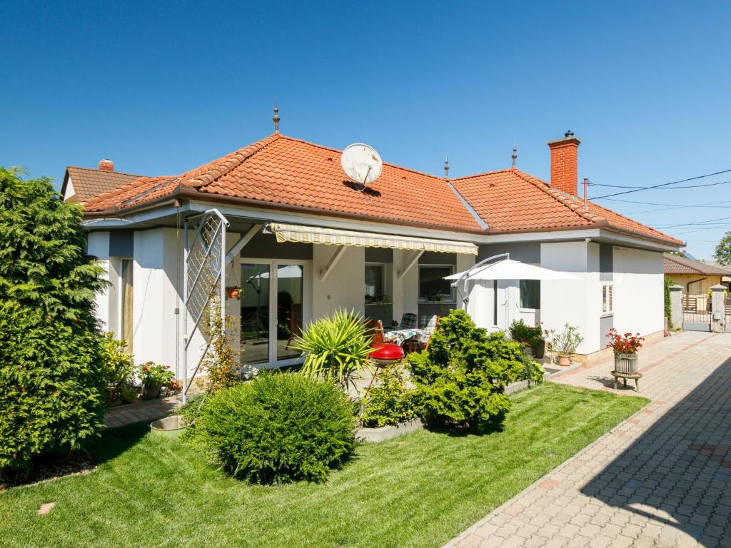 ein Haus mit einem Garten mit grünem Gras in der Unterkunft Holiday Home Ildiko by Interhome in Balatonlelle