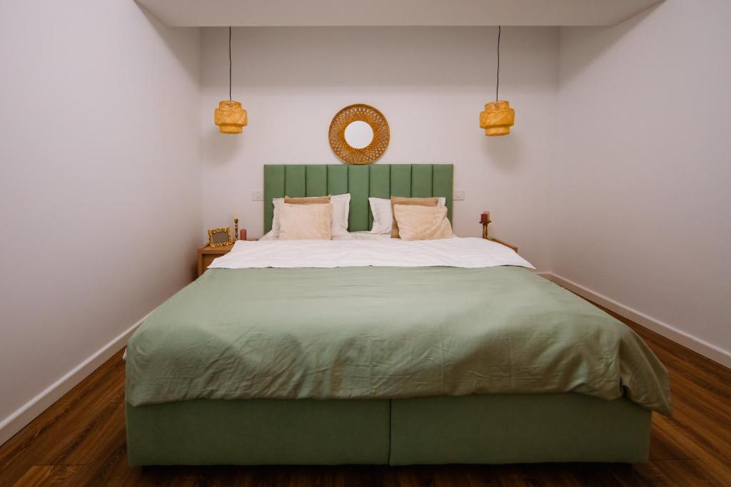 a bedroom with a large bed with a green headboard at Mountain View with Terrace in Sinaia