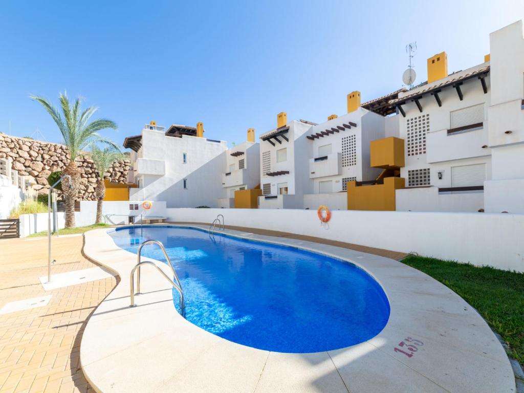 a villa with a swimming pool in front of a building at Apartment Lomas del Mar V-2 by Interhome in Playas de Vera
