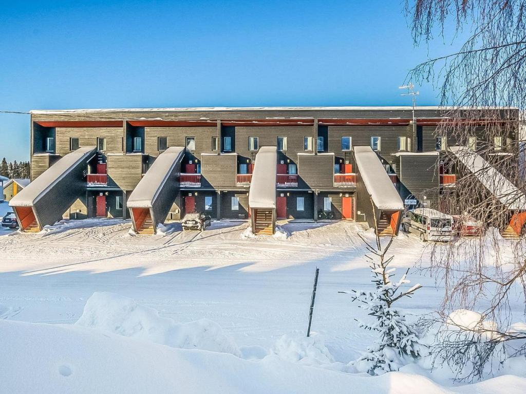 un edificio con un montón de toboganes en la nieve en Holiday Home Skivillas 61 ukkohalla - b1 by Interhome, en Hyrynsalmi